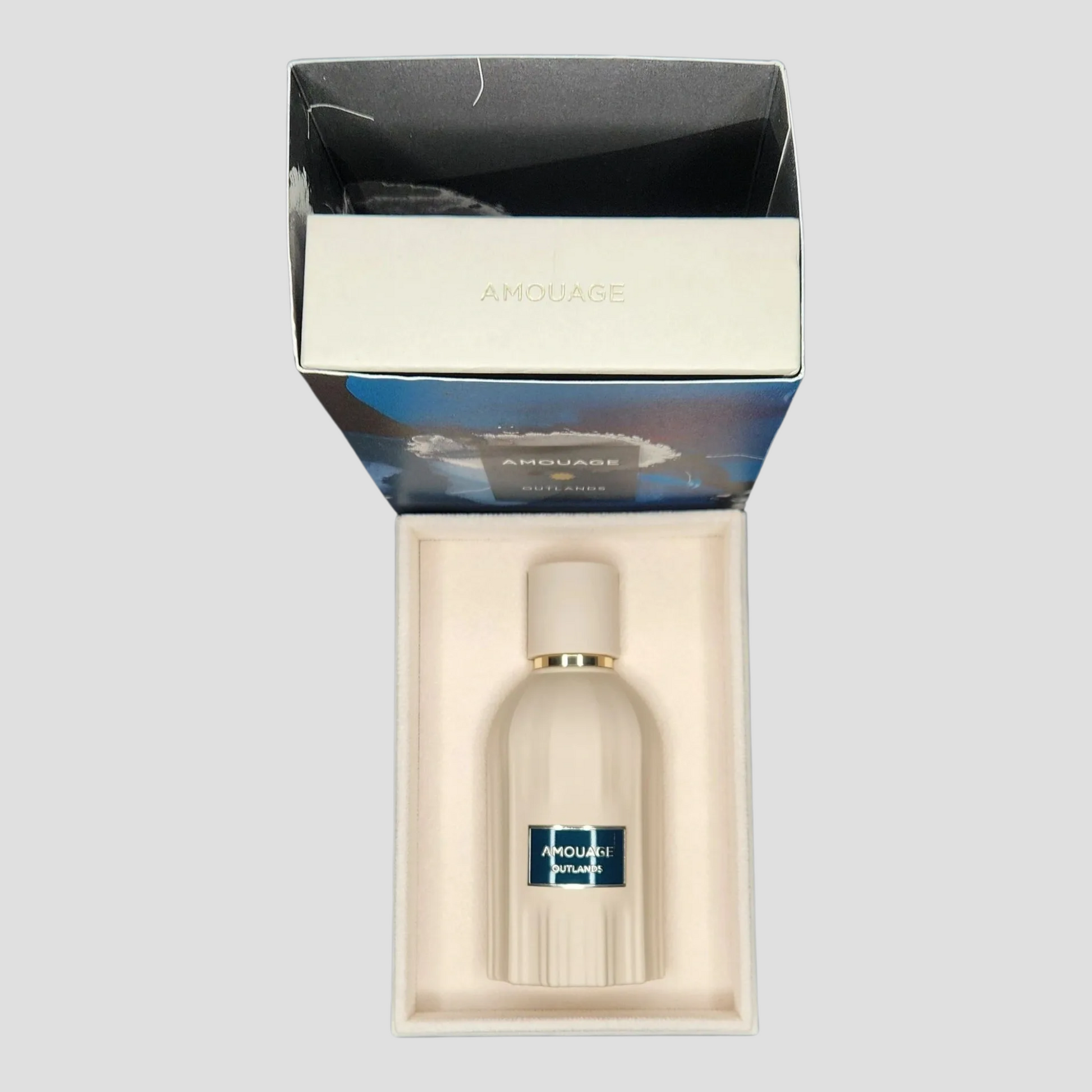 Amouage outlands bottle in case on a light grey background