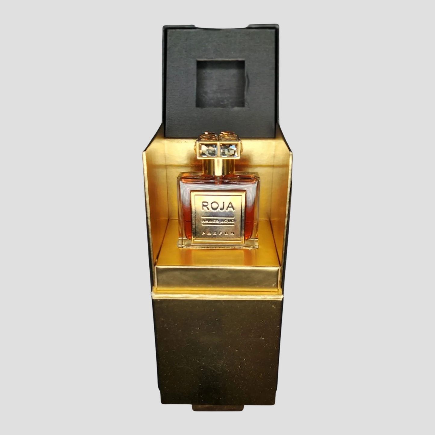 Roja Amber Aoud Perfume in packaging on a light grey background
